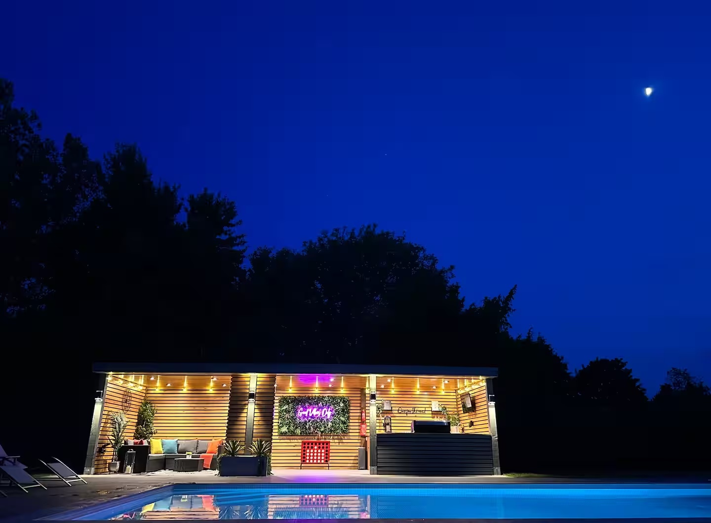 Moonlit sky above the illuminated garden bar and pool